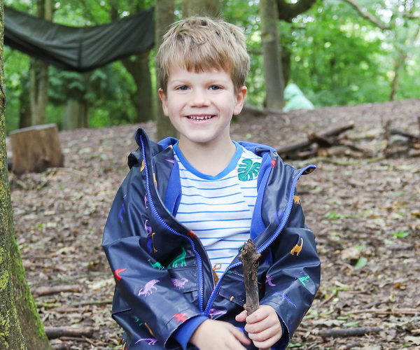 A young child smiling whilst having fun in the Forest