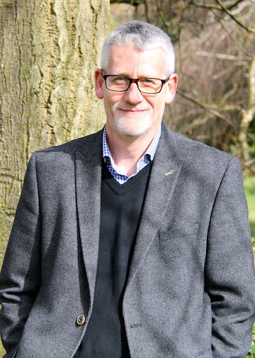 Steve Price standing outside by a tree