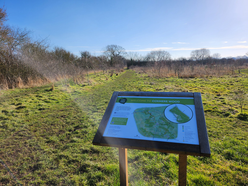 welcome board at coxmere wood with a grassy background