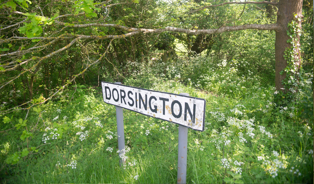 A road sign saying 'Dorsington' along the side of a road.