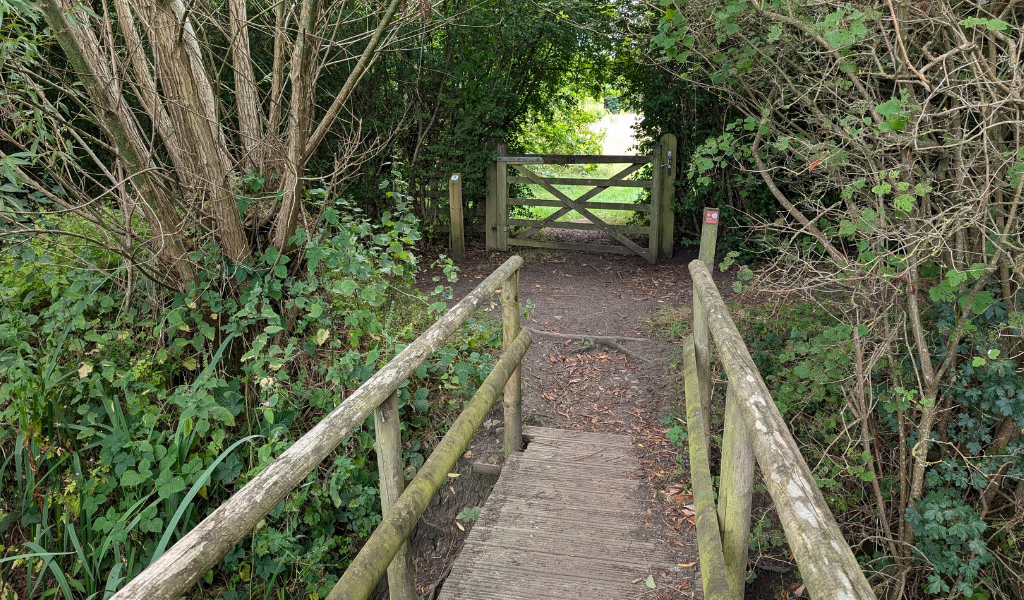 A view of a wooden bridge across Noleham Brook.