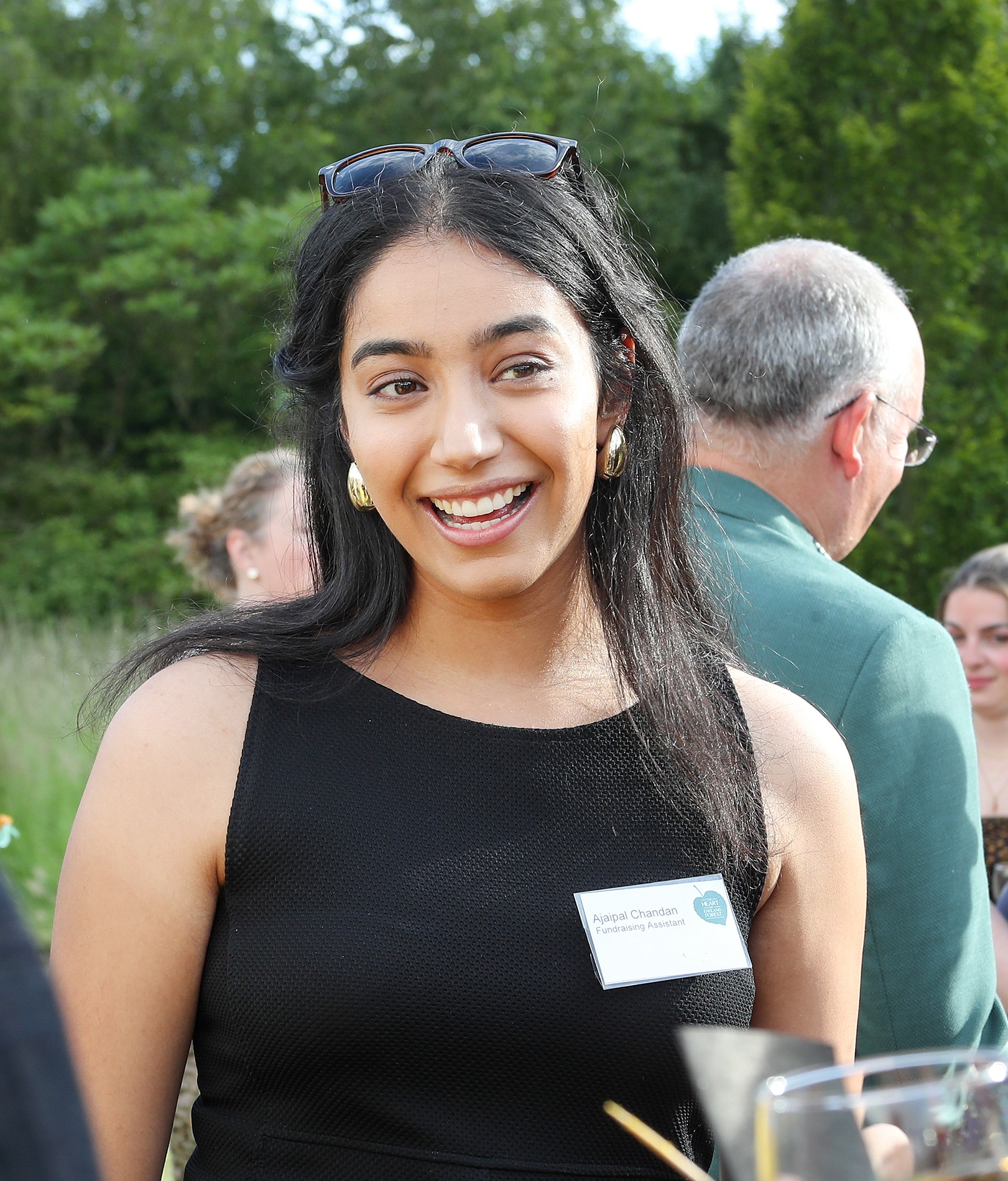 Ajaipal Chandan – Fundraising Assistant smiling while talking to event guests at the mid summer reception