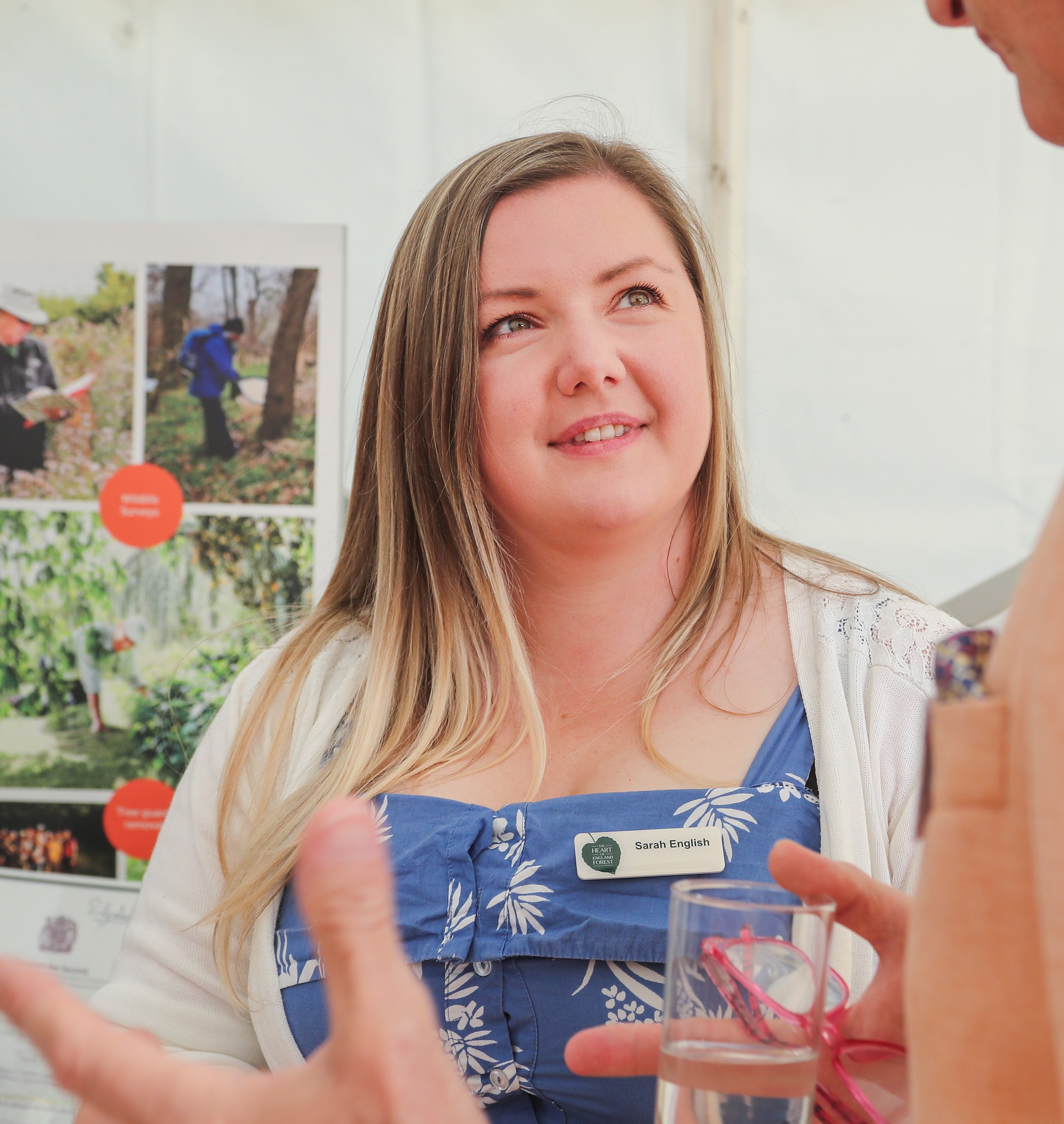 A photo of Sarah speaking with the public at an event.