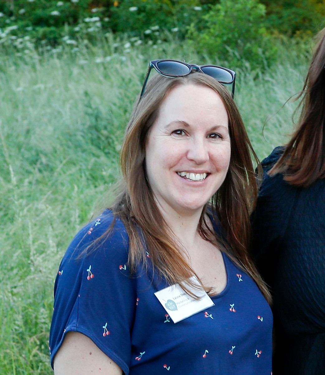 Laura Diep – Head of Marketing & Communications smiling at the camera with sunglasses on her head