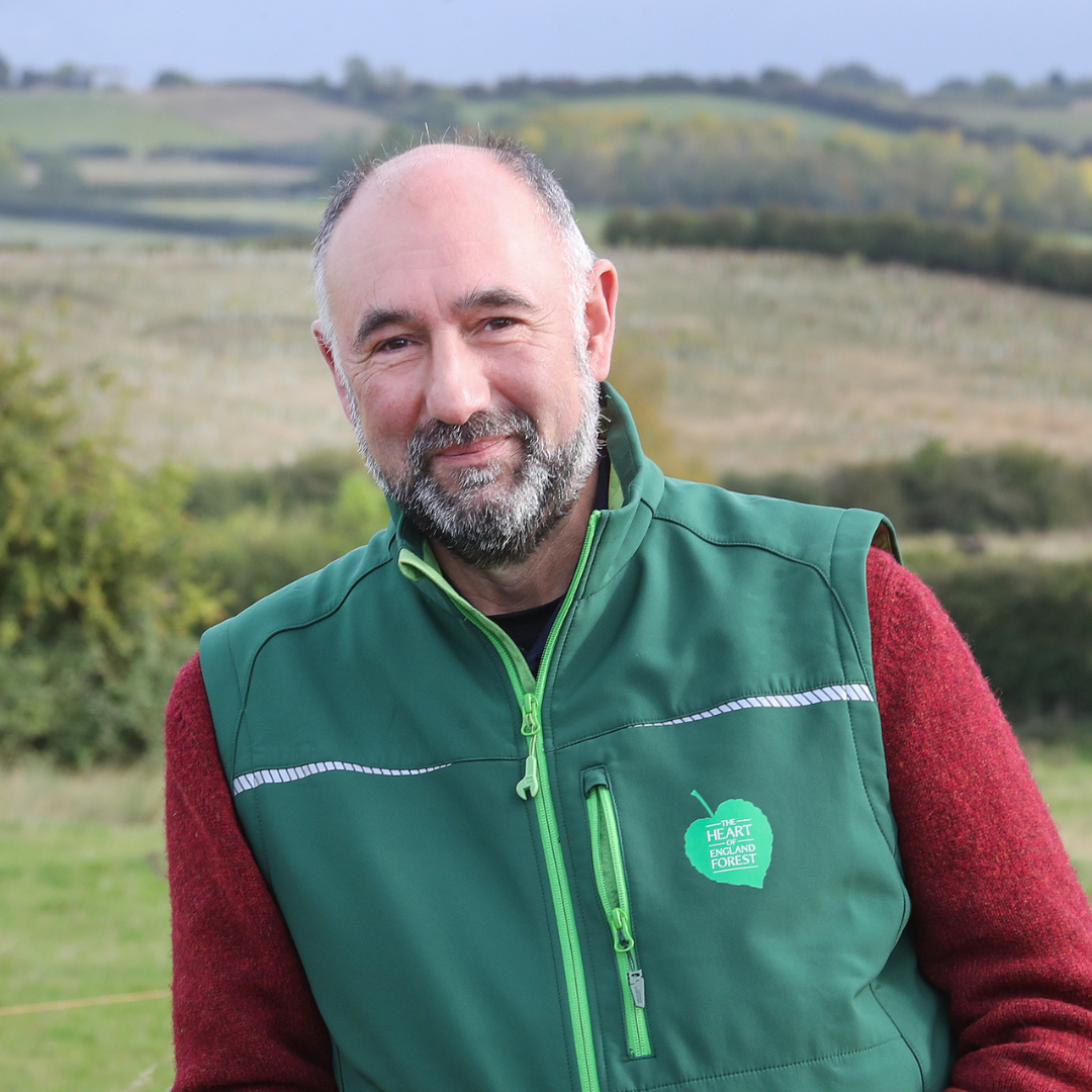 Ed Leszczynski looking at the camera smiling wearing a branded jacket