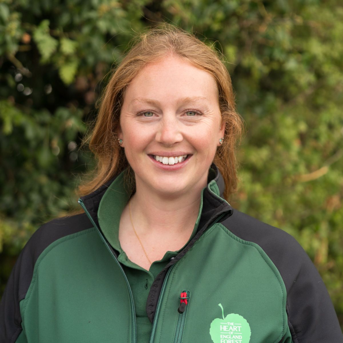 A headshot of Fay Cowie smiling at the camera in a branded tshirt