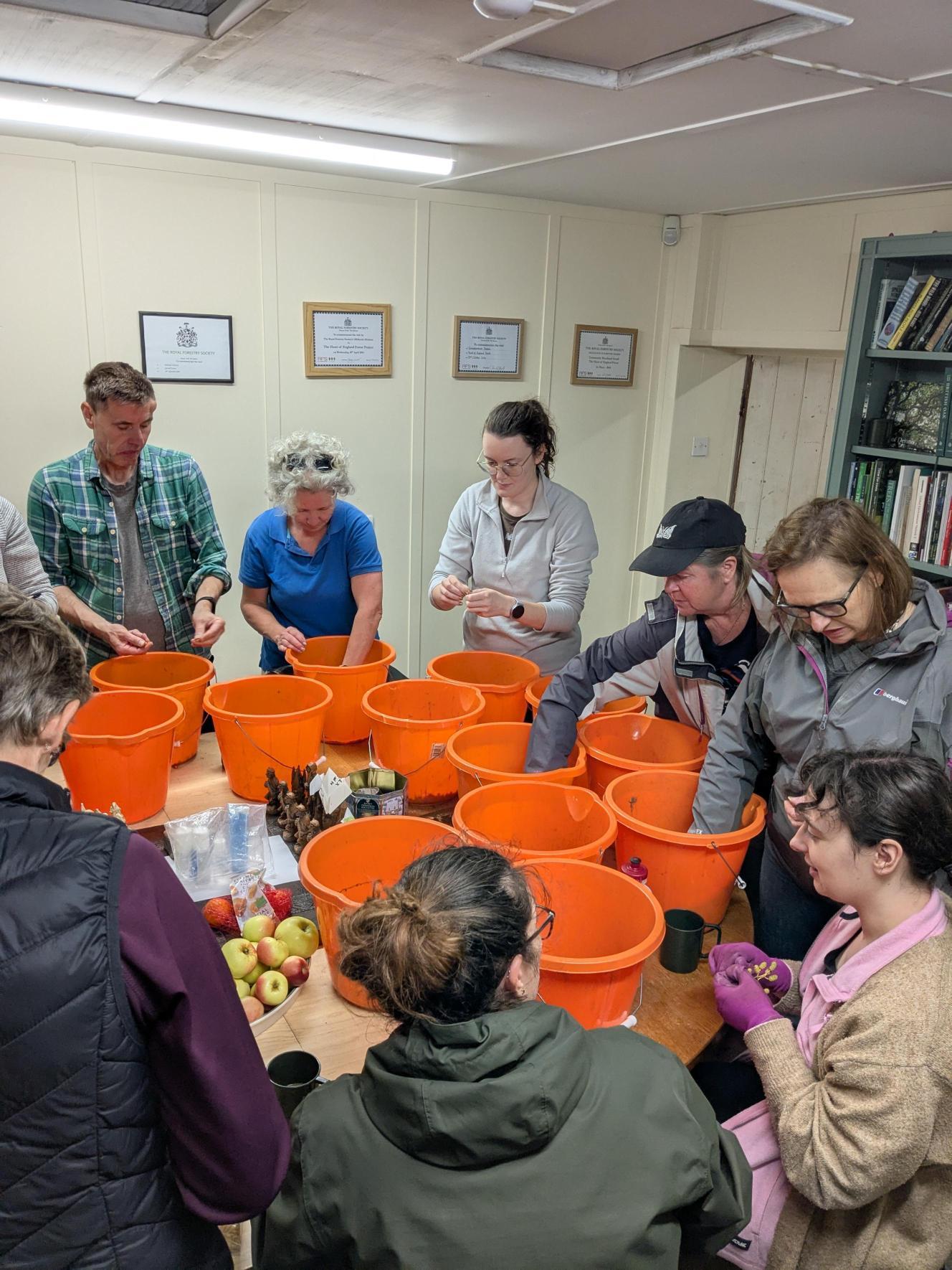 Evening volunteers sitting round a table seed processing inside.