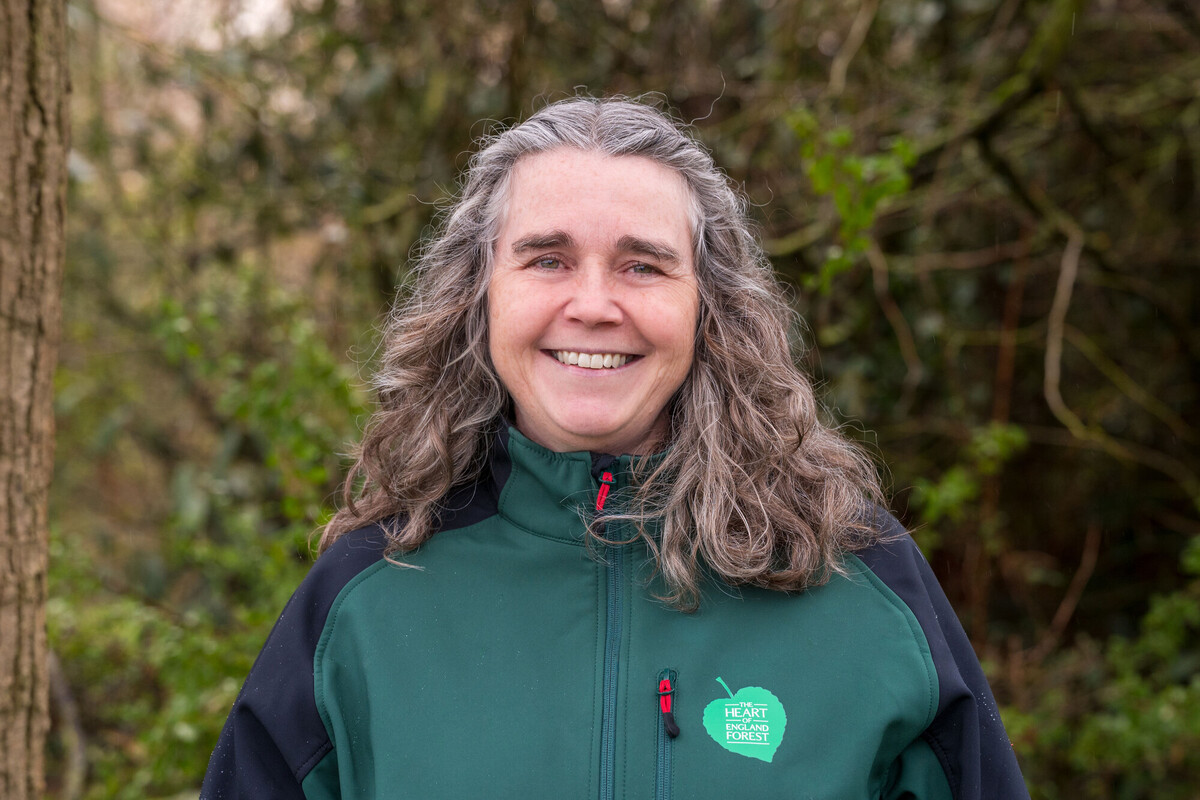A picture of Ellie Topham smiling at the camera, wearing branded uniform