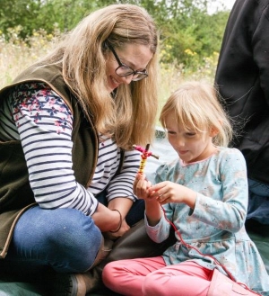 A mother and daughter making a worry doll together