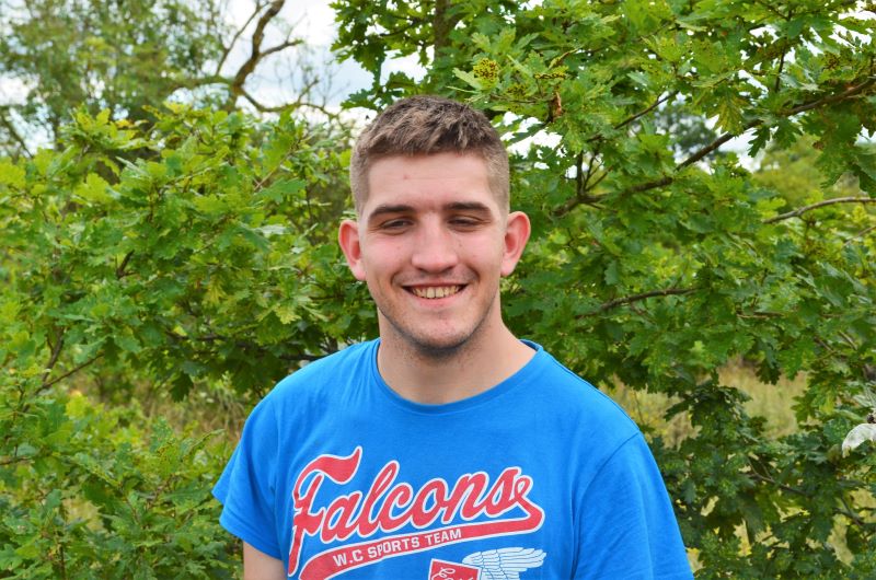 Head and shoulders shot of supported intern Alex in the Forest with trees behind