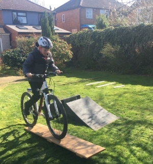 A boy enjoying a homemade obstacle course on his bike
