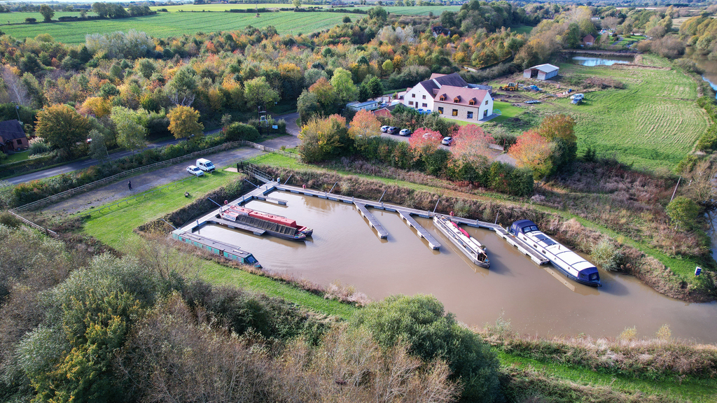 Aerial view of the flood-safe pontoon berths at Forest Bank Moorings with autumnal trees in the background.