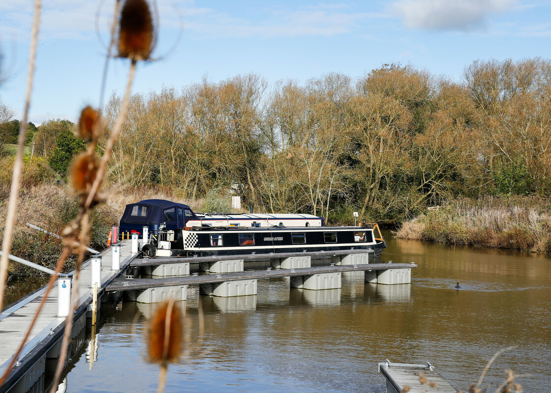 View of flood-safe pontoons at Forest Bank Moorings with a boat moored and autumnal trees in the background