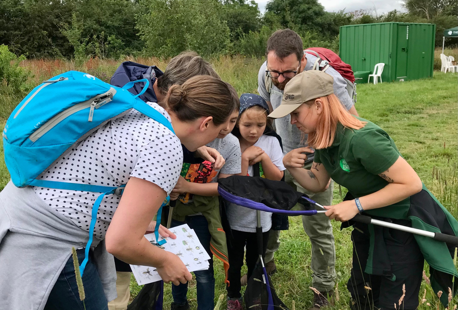 Biodiversity Assistant Avery with a group of attendees looking in to a net at BioBlitz 2023