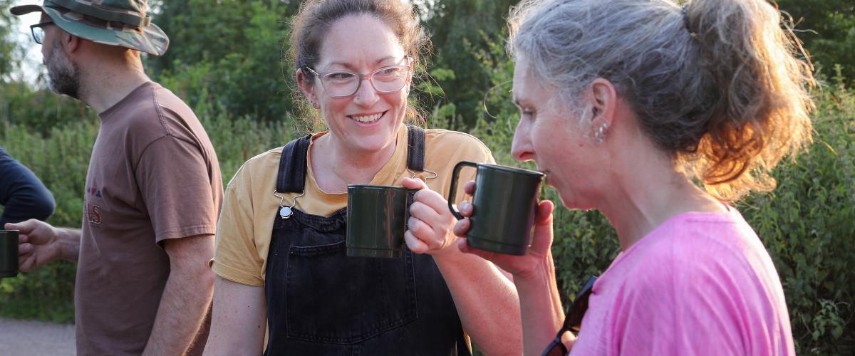 Two volunteers chatting and having a cup of tea at the end of an evening volunteer session