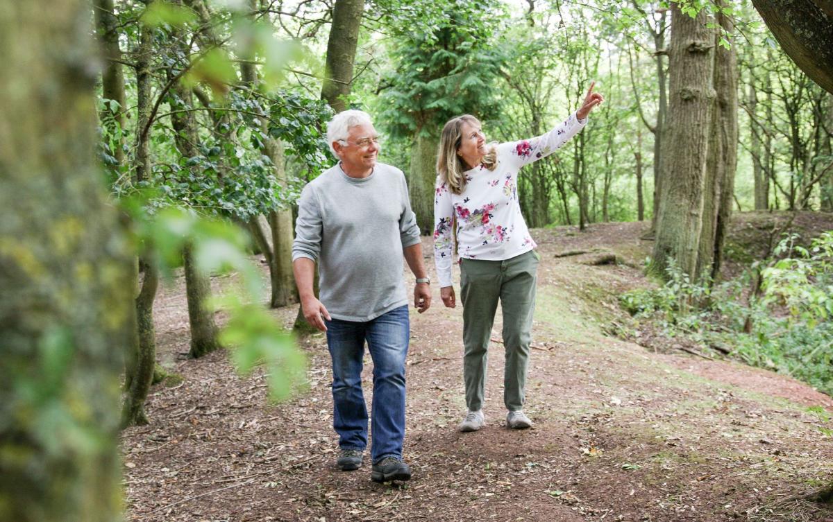 Older couple walking amongst the trees in the Forest 