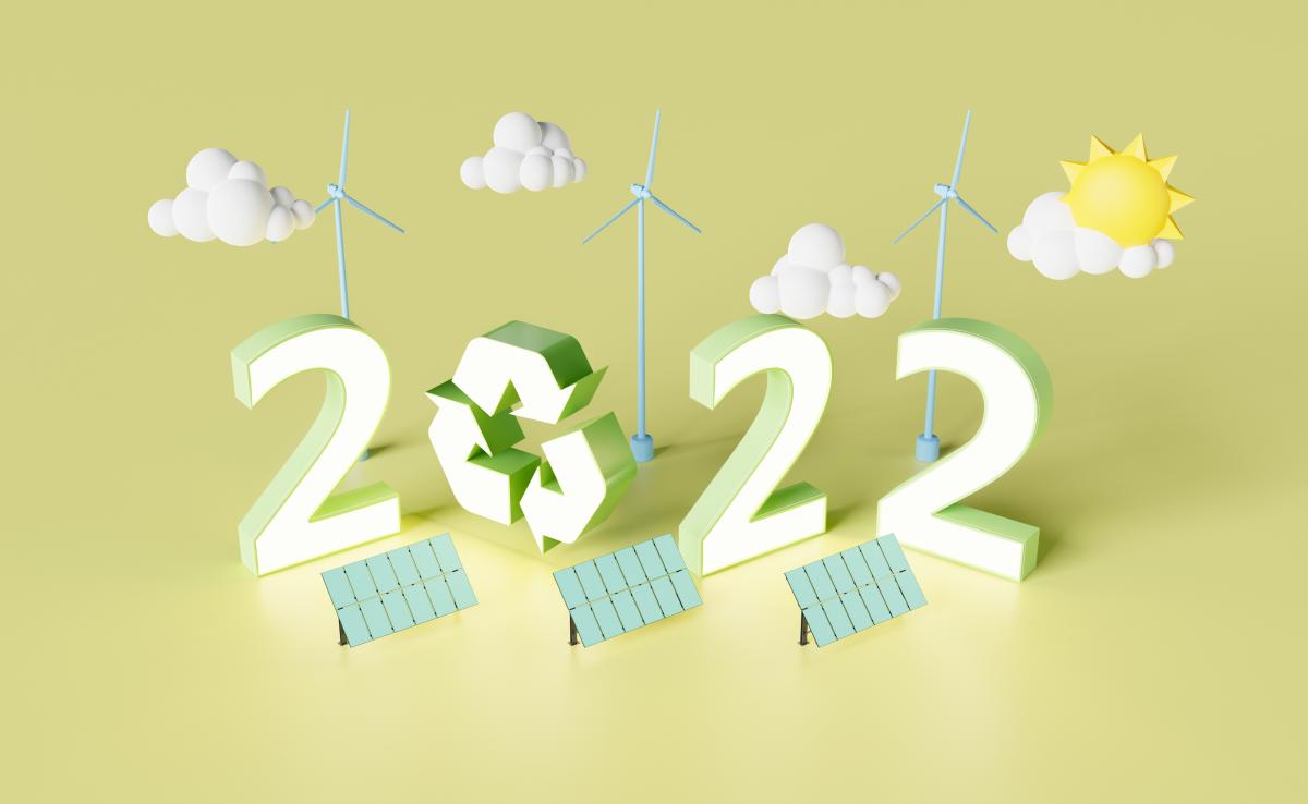 Graphic showing 2022 with a recycling symbol, wind turbines behind and solar panels in front