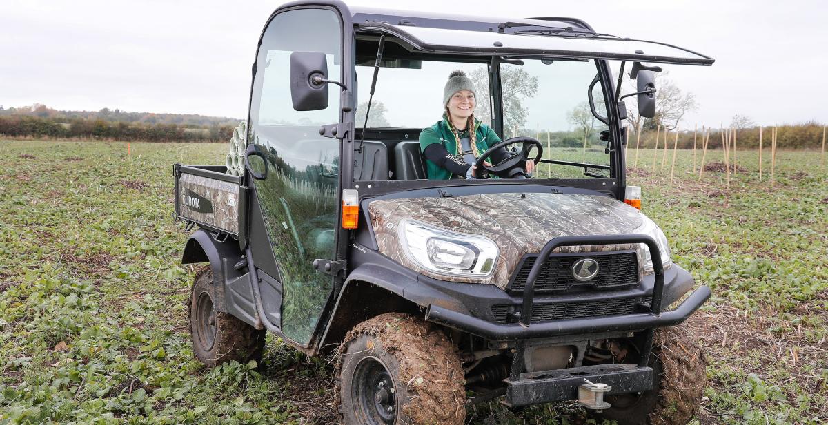 Intern Alicia driving a small 4x4 vehicle in the tree planting field 