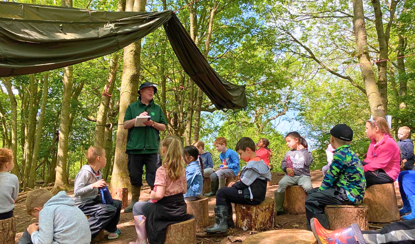 Phil, Senior Outdoor Teacher, teaching a class of children on a summers day