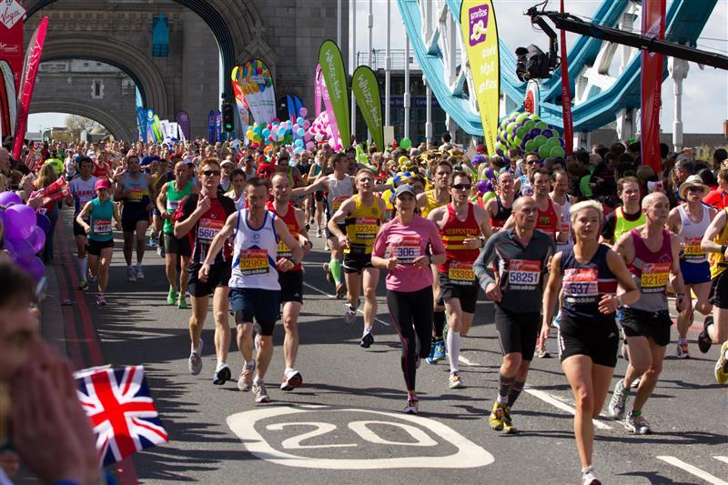 Shutterstock: A group of people running through the streets of London during the London Marathon. All being cheered on by hundreds of supporters