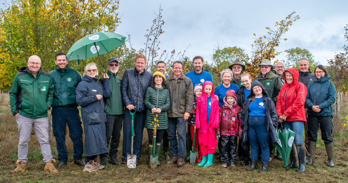 Local MPs Chris Bloore, Manuela Perteghella, and Nigel Huddleston, Chair of Trustees Heather Acton, Chief Executive Andy Parson, Trustees, and volunteers with a newly planted  tree in the Heart of England Forest