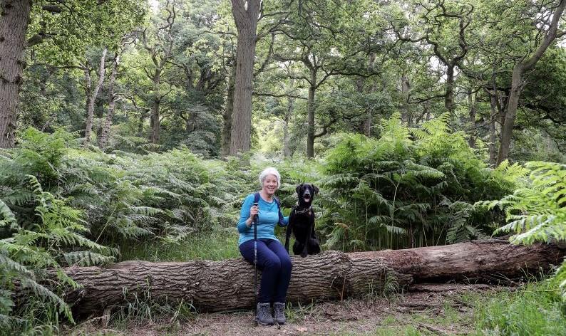 Soozy and her dog, Beau, sitting on a fallen tree trunk in the Forest