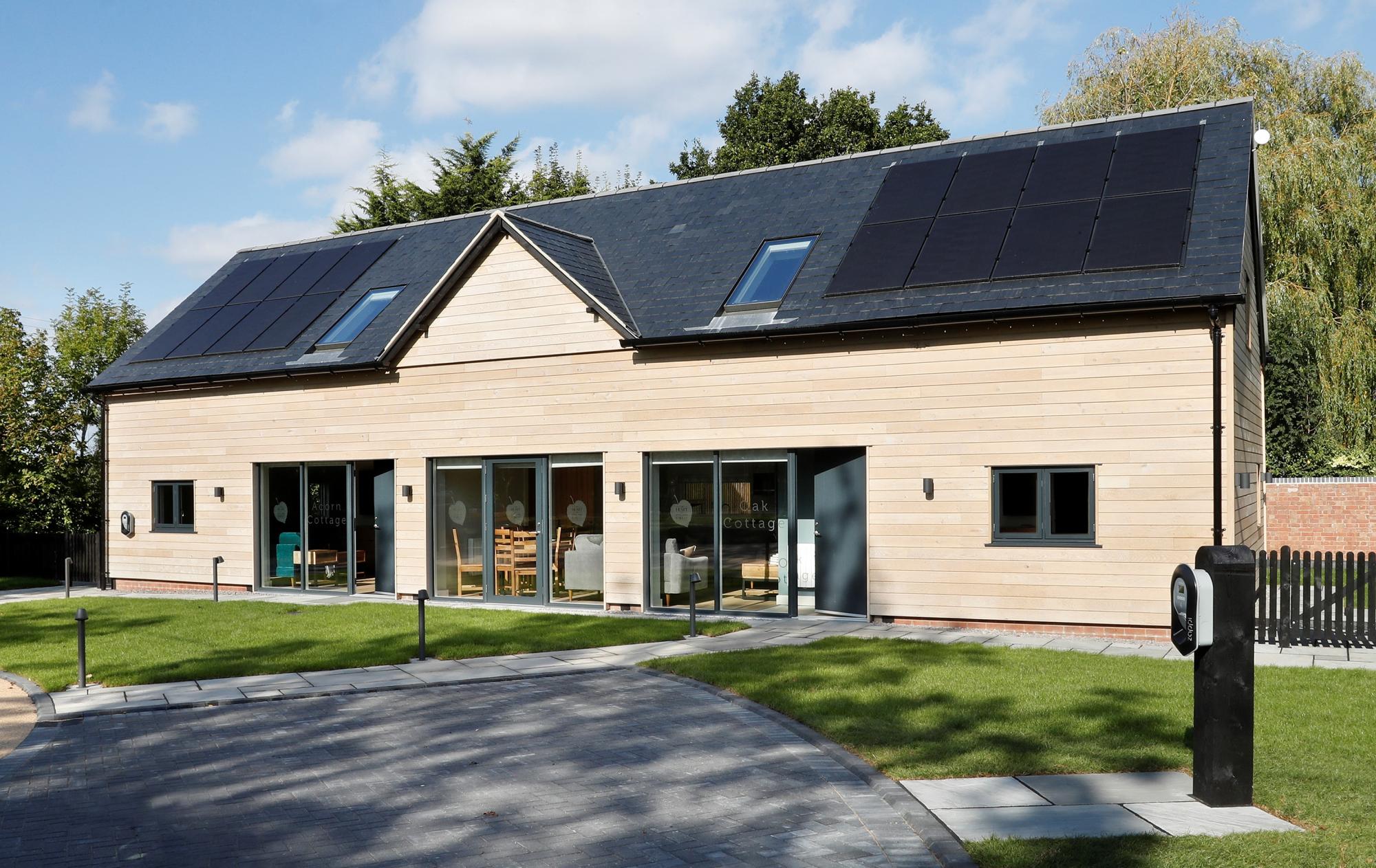 The outside of the Heart of England Forest holiday lets with black solar panels on the roof.