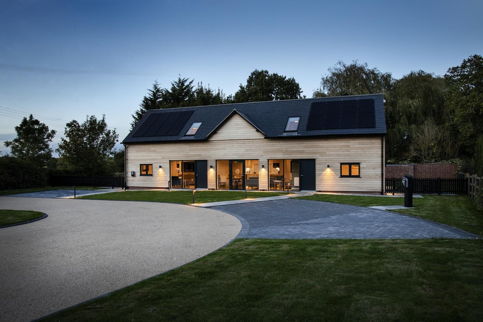 View of the outside of the holiday cottages at dusk with the interior lights on