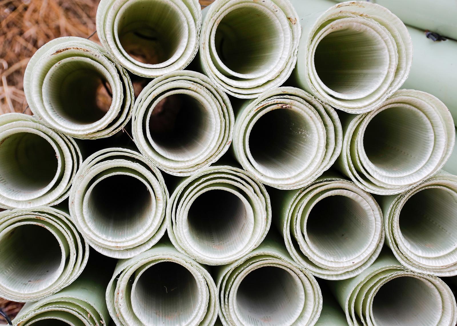 Close up photo of the ends of plastic tree tubes in a pile