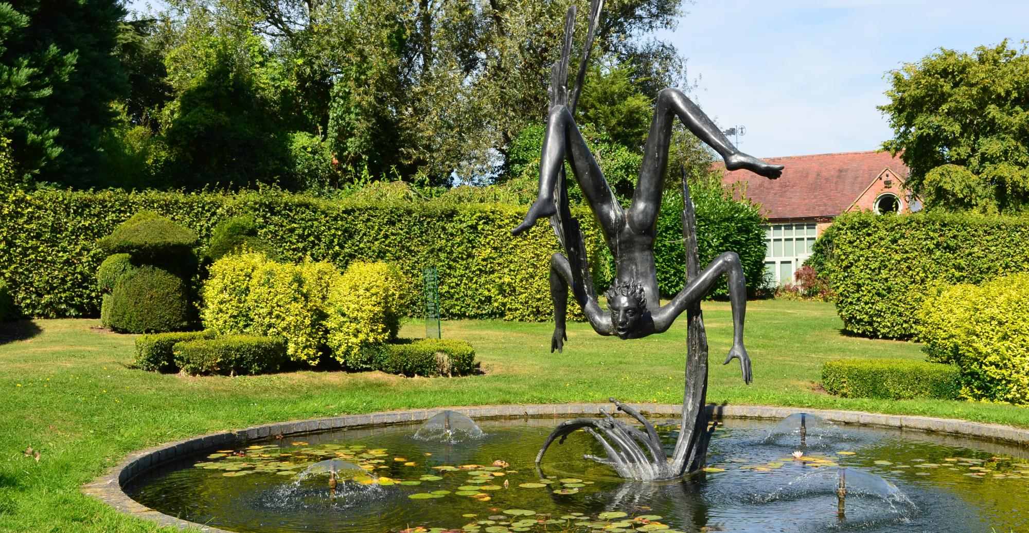 Bronze statue of Icarus over a pond in the Garden of Heroes and Villains