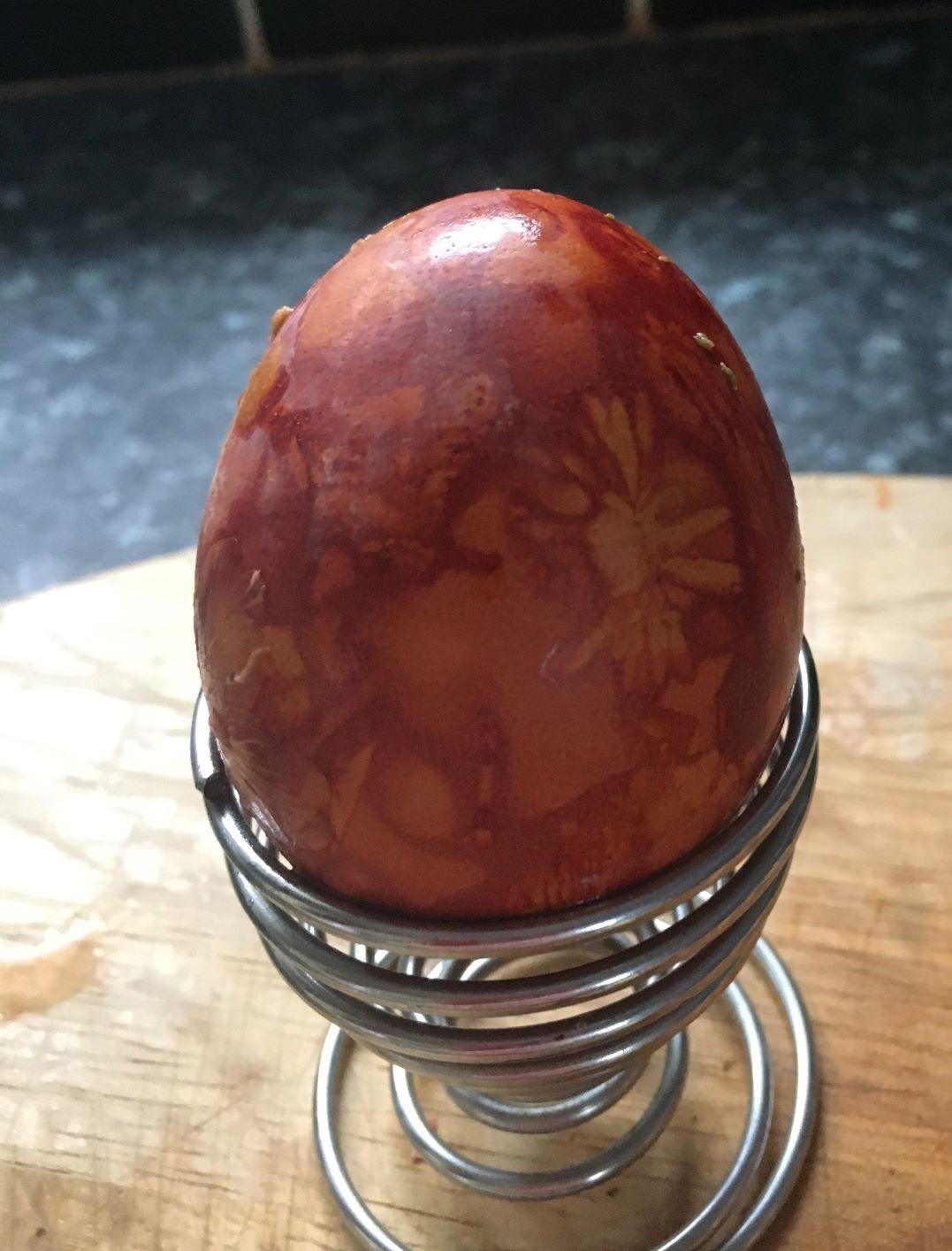 Egg that has been dyed with onion skins in a metal egg cup