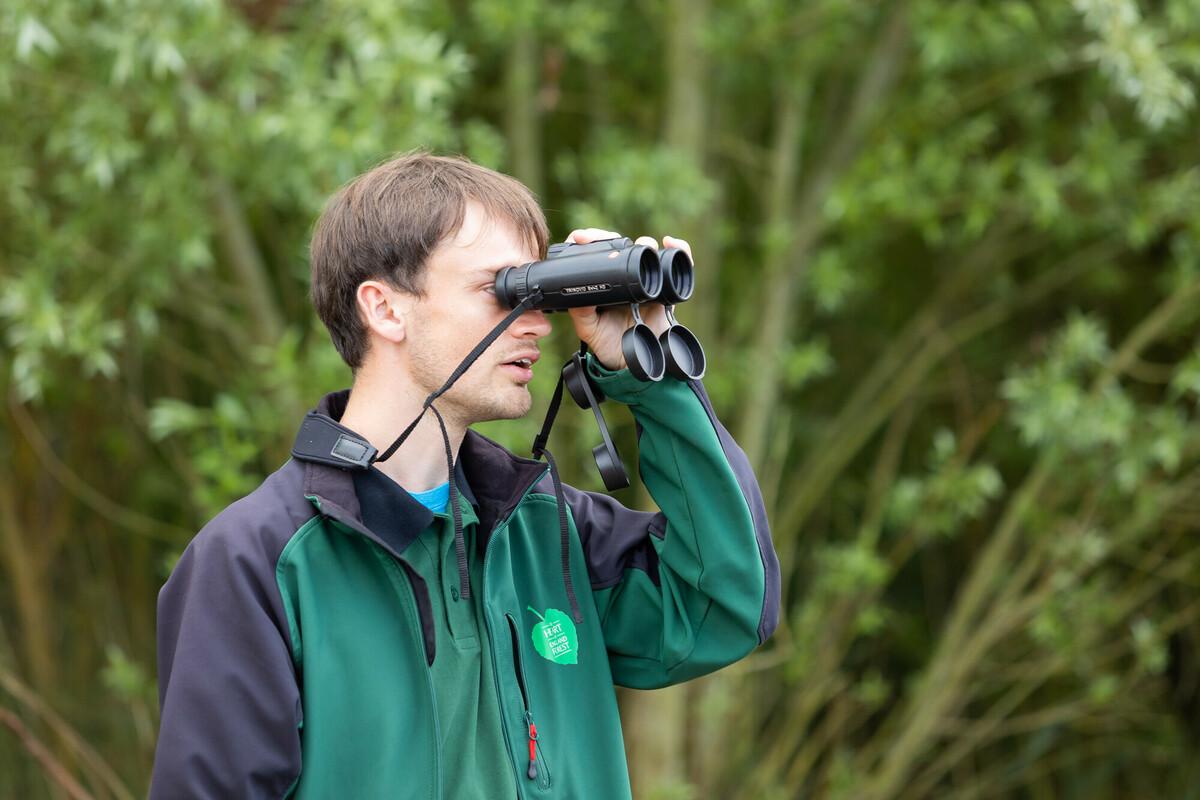 Staff member Sam looking through binoculars 