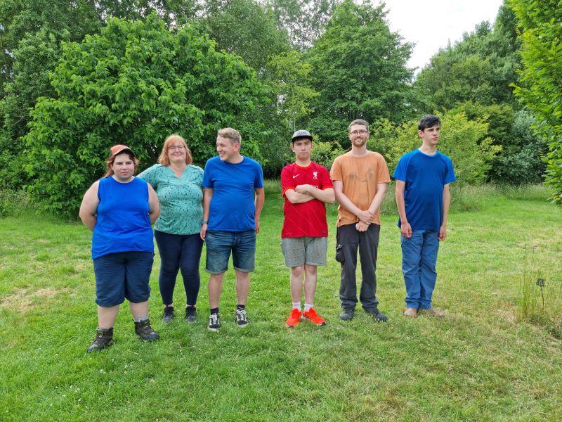 Supported interns standing in the arboretum 