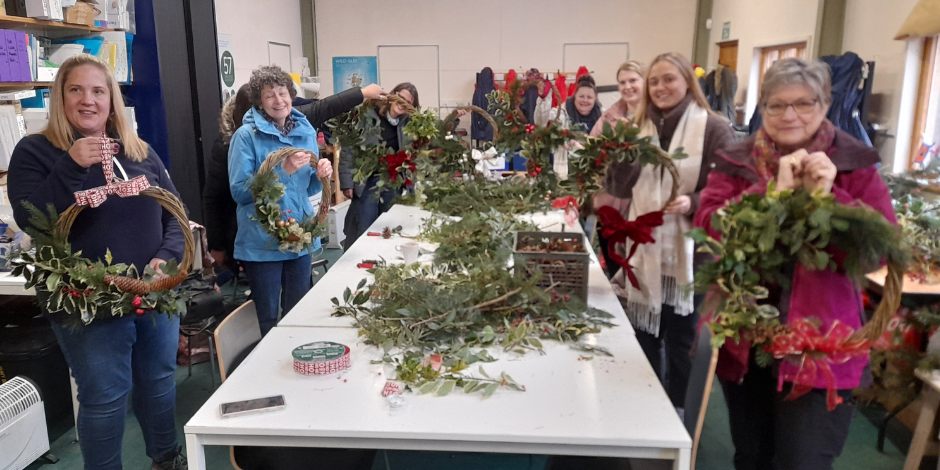 A group of previous attendees showing their newly made Christmas wreaths