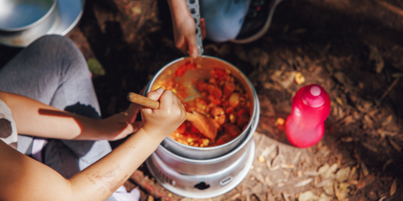 Children cooking in the woods.