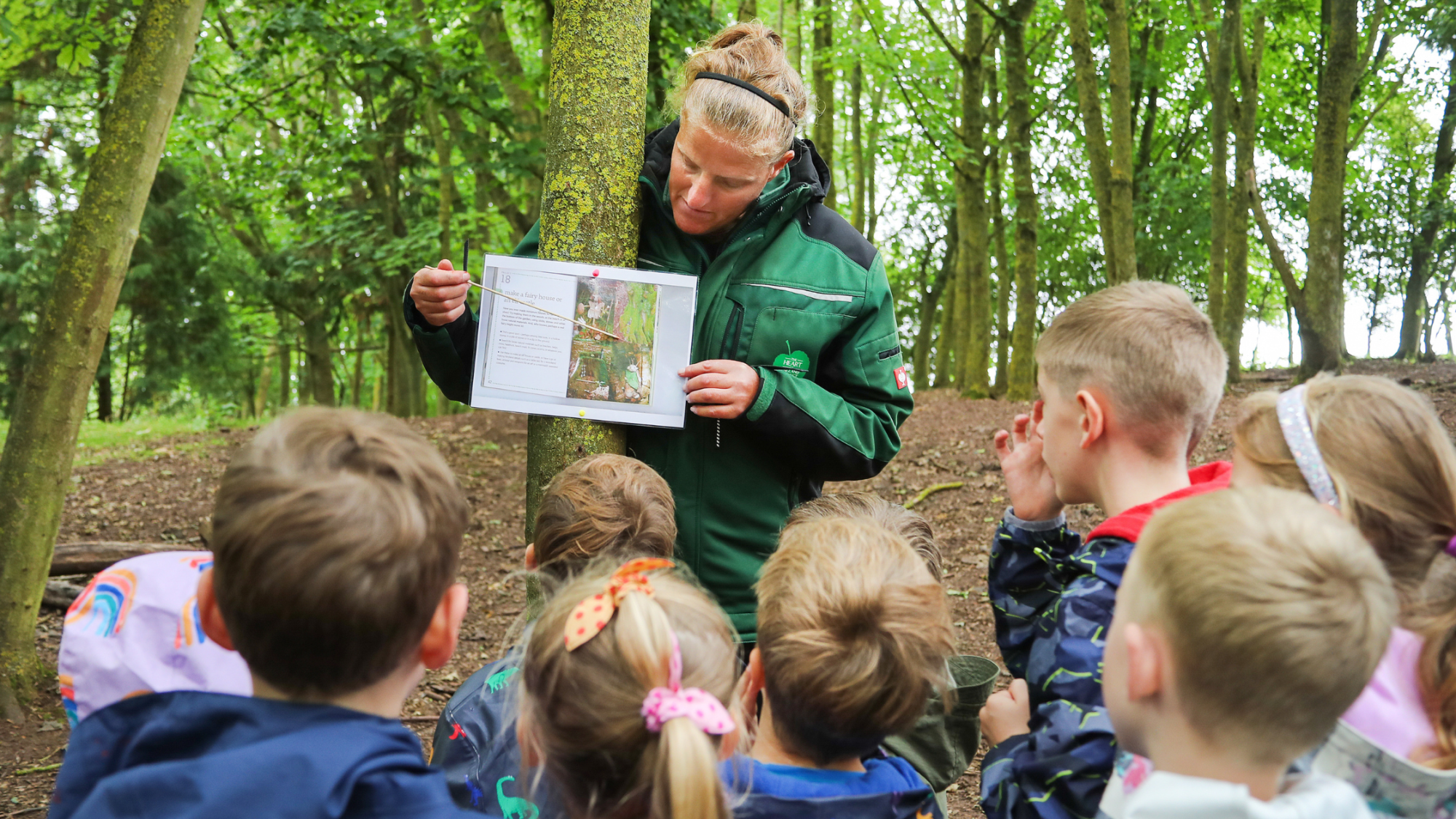 Helena teaching a group of children out side in the Forest