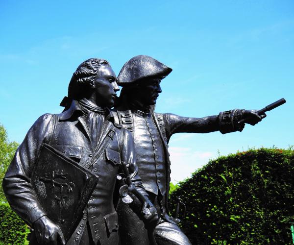 A sunny sculpture of two men in the garden of heroes and villains