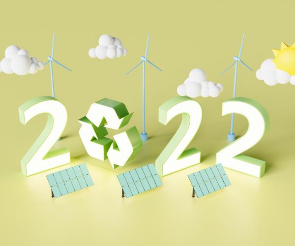 Graphic showing 2022 with a recycling symbol, wind turbines behind and solar panels in front 