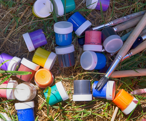 Paints and paint brushes on the grass 