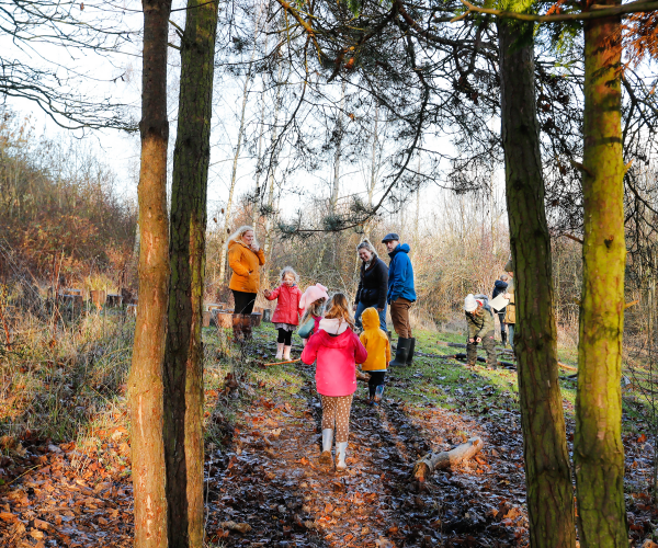 A group of mini foresters and parents walking through the Forest
