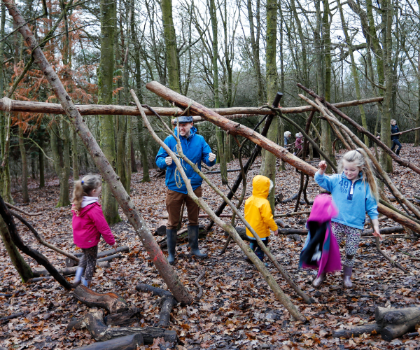 A group of children having fun making a den at Mini Foresters