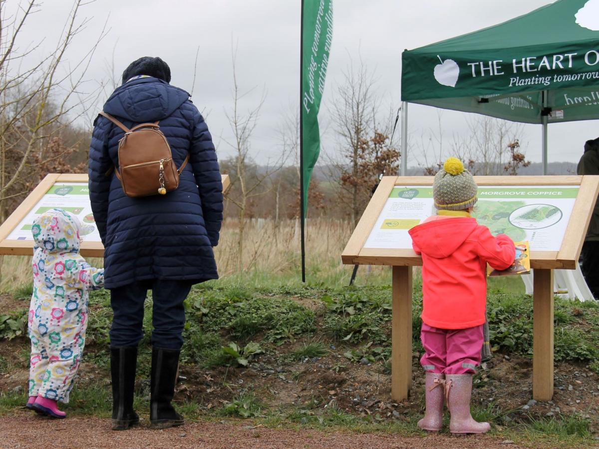 Lady and two children looking at a map board at the start of a Forest walk 