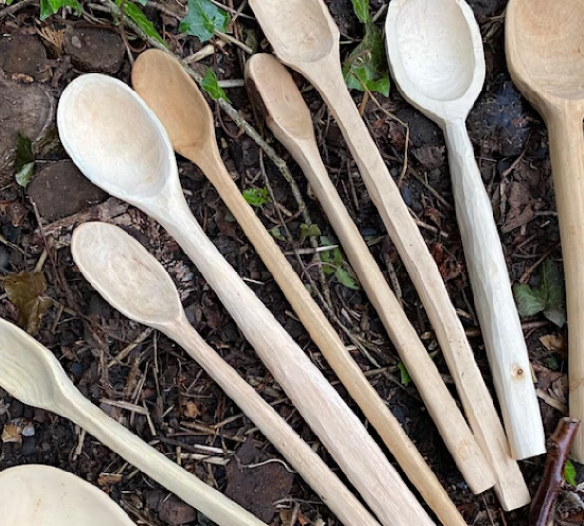 carved wooden spoons laid out on the Forest floor