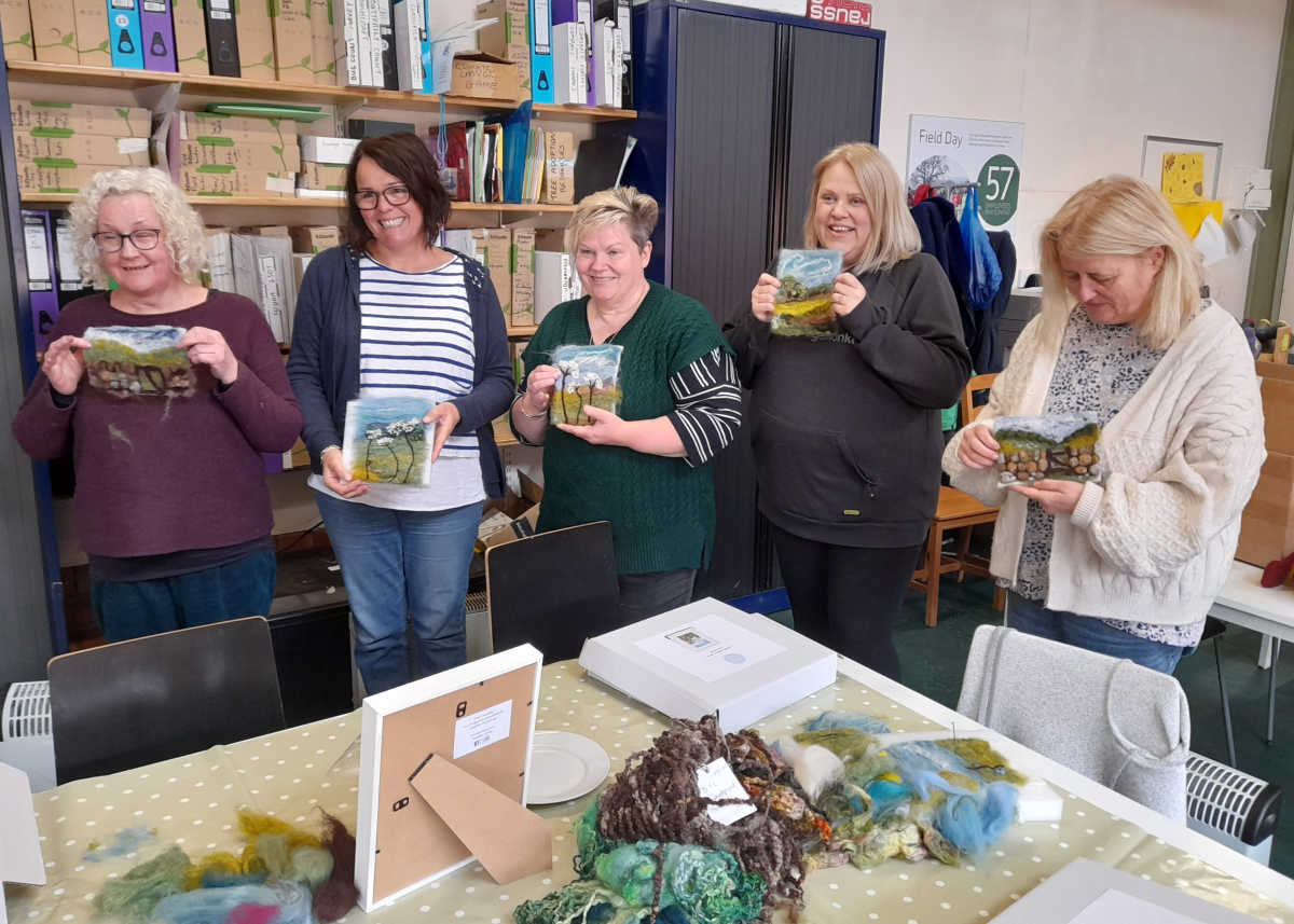 A group of previous participants proudly showing their needle felt creations