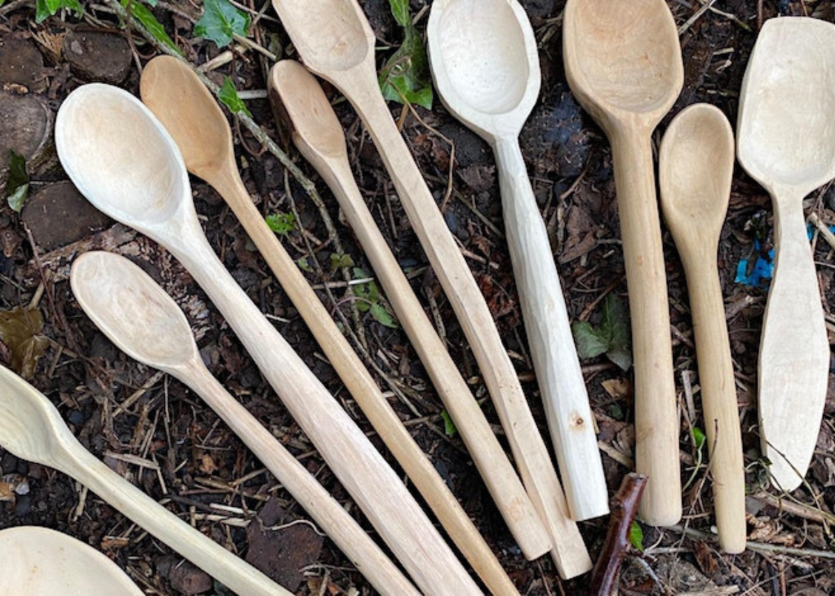 A group of handmade wooden spoons laid out in a row