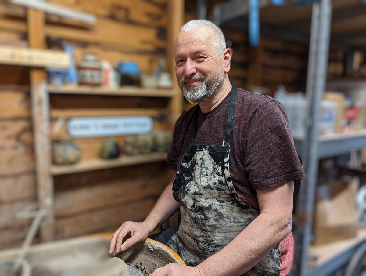 A photograph of Dave from the great pottery throw down, sat in his ceramics studio
