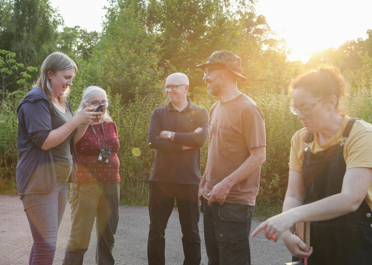 A group of wonderful volunteers all standing around as the sun is setting, having fun and a chat
