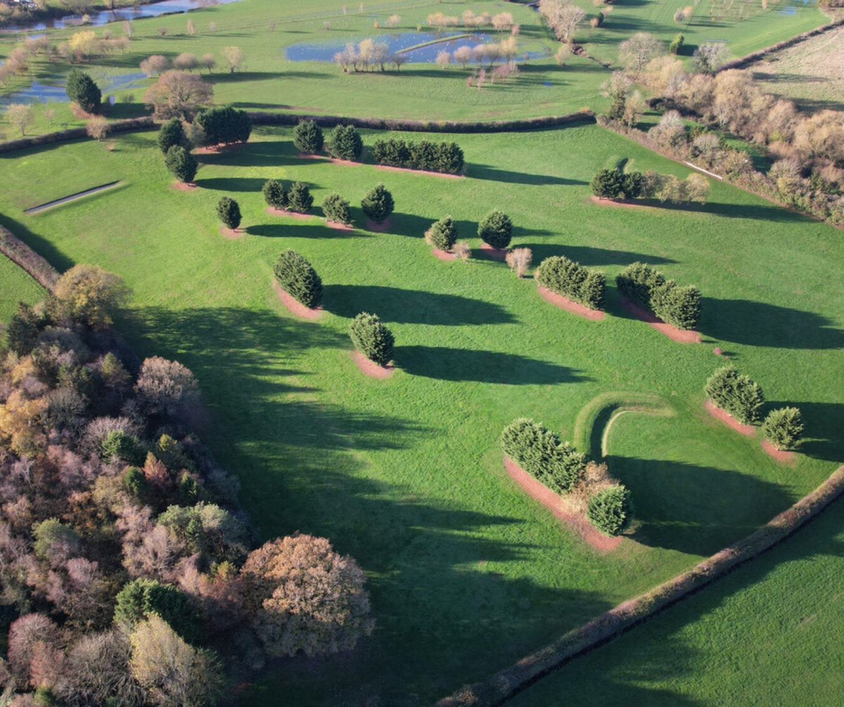  drone image of Harvington Gold course, with a pond, grass and trees