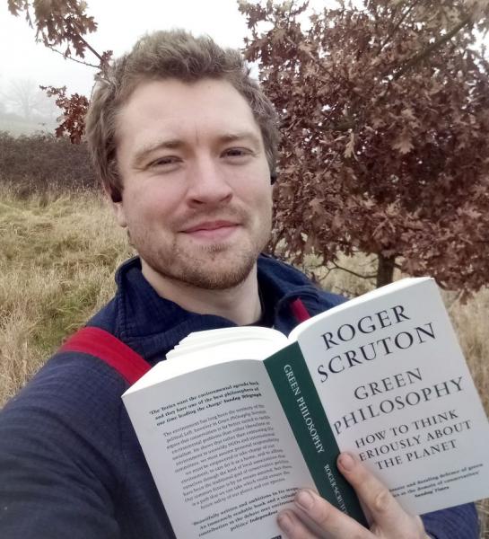 Our Forestry intern, Tom, holding his copy of his favourite book