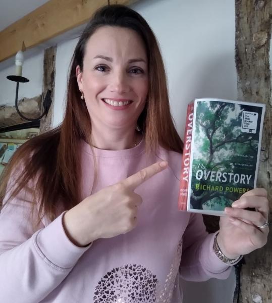 Our Community Partnerships Officer holding her copy of 'The Overstory' by Richard Powers